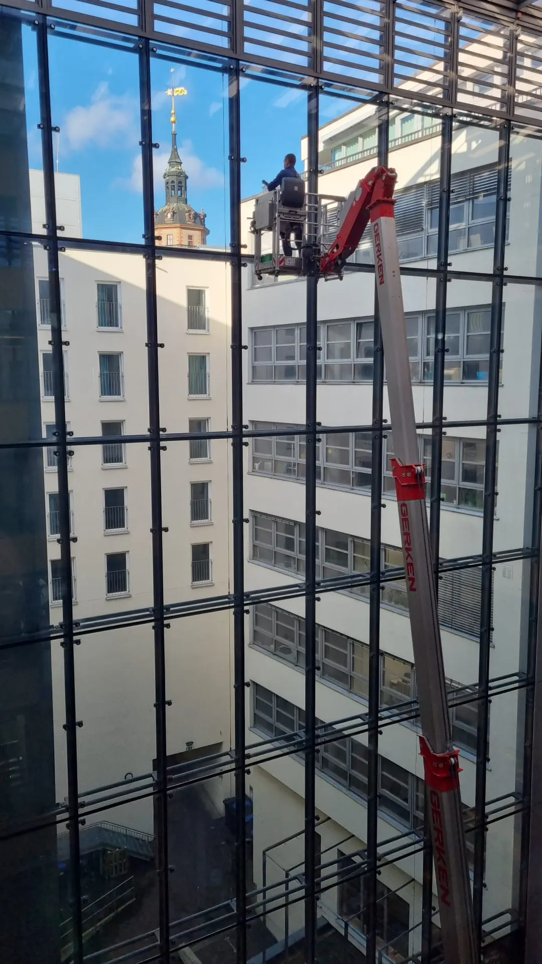 pureco Mitarbeiter bei der Glasfassadenreinigung mit Hubsteiger an einer Vorhangfassade in Leipzig